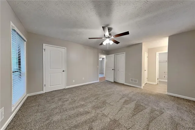 a view of an empty room with a ceiling fan