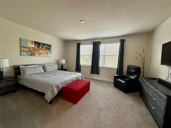 a spacious bedroom with a bed and a couch