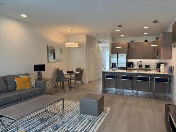 a kitchen with a table chairs and a wooden floor