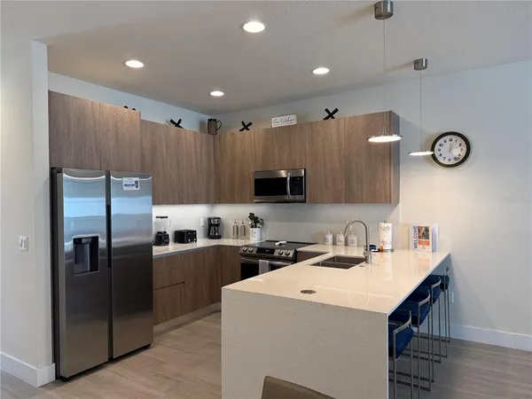 a kitchen that has a lot of cabinets and stainless steel appliances