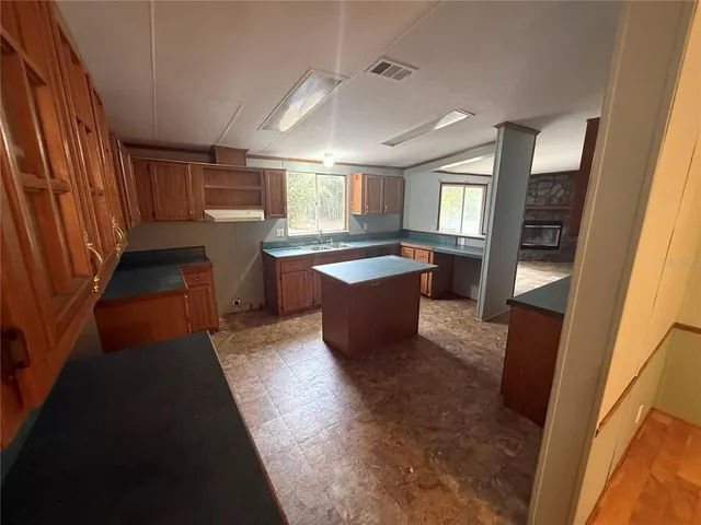 an empty room with windows and refrigerator