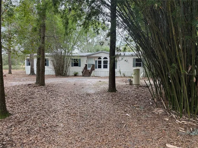 a view of a house with a yard and tree