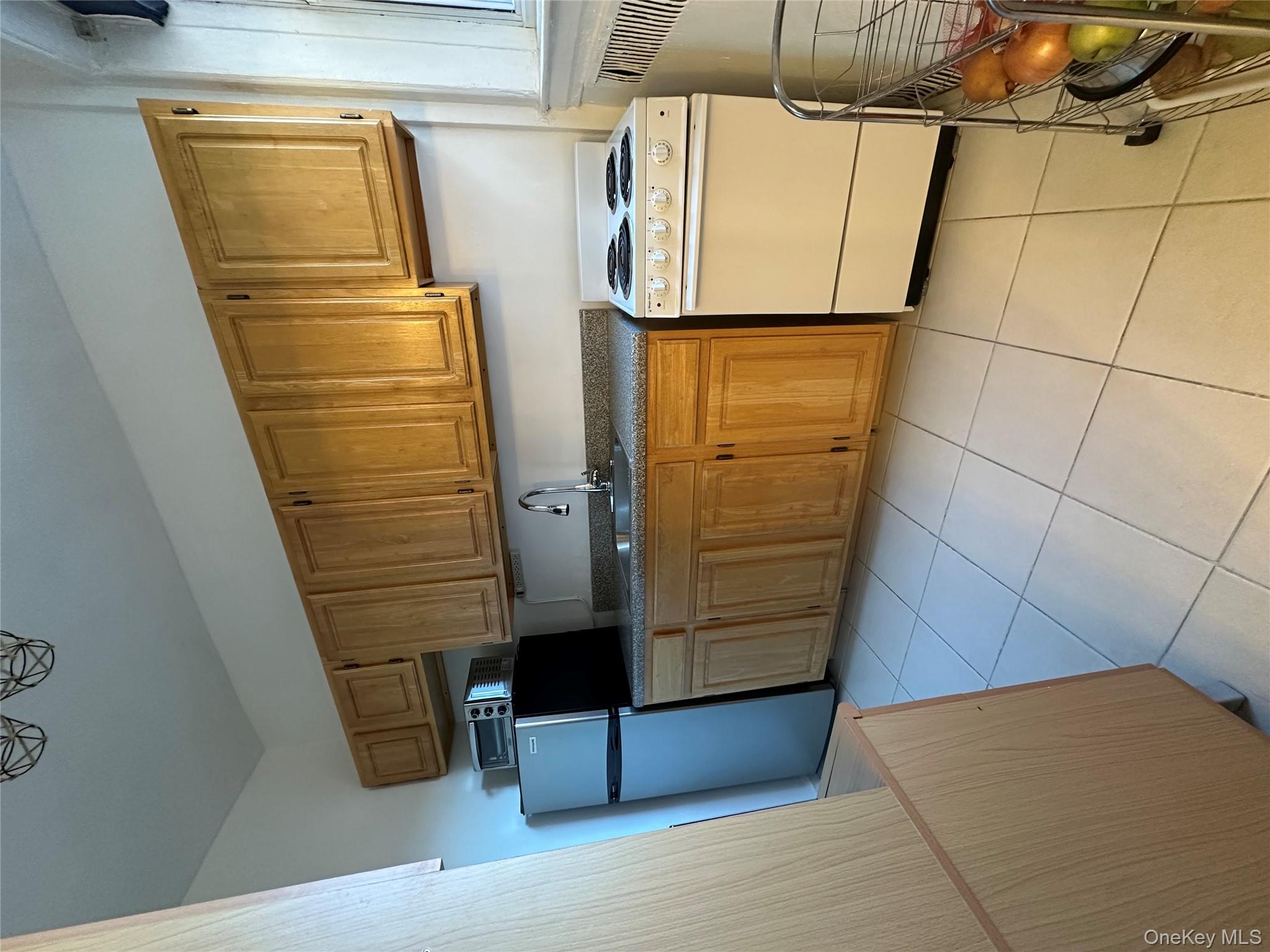 86-10 34th Avenue, Unit 624 Queens, NY 11372 - Photo 7 of 20 Kitchen featuring stove, dark countertops, light tile patterned floors, and refrigerator