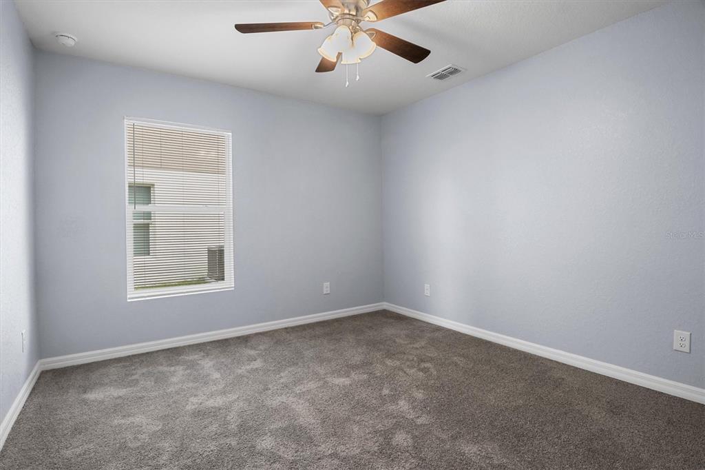 4153 Oak Loop Mulberry, FL 33860 - Photo 7 of 11 an empty room with a window and a fan
