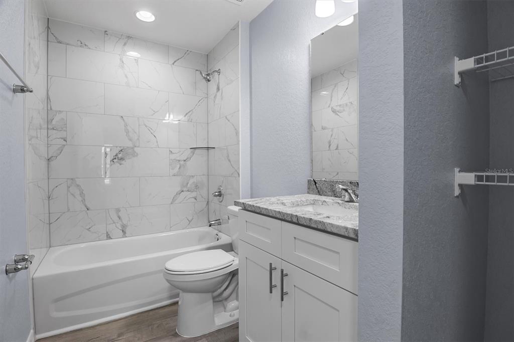 4153 Oak Loop Mulberry, FL 33860 - Photo 8 of 11 a bathroom with a granite countertop toilet a sink and a bathtub