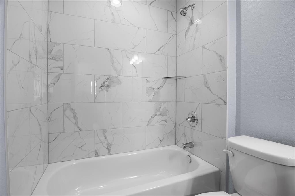4153 Oak Loop Mulberry, FL 33860 - Photo 9 of 11 a bathroom with a bathtub and toilet