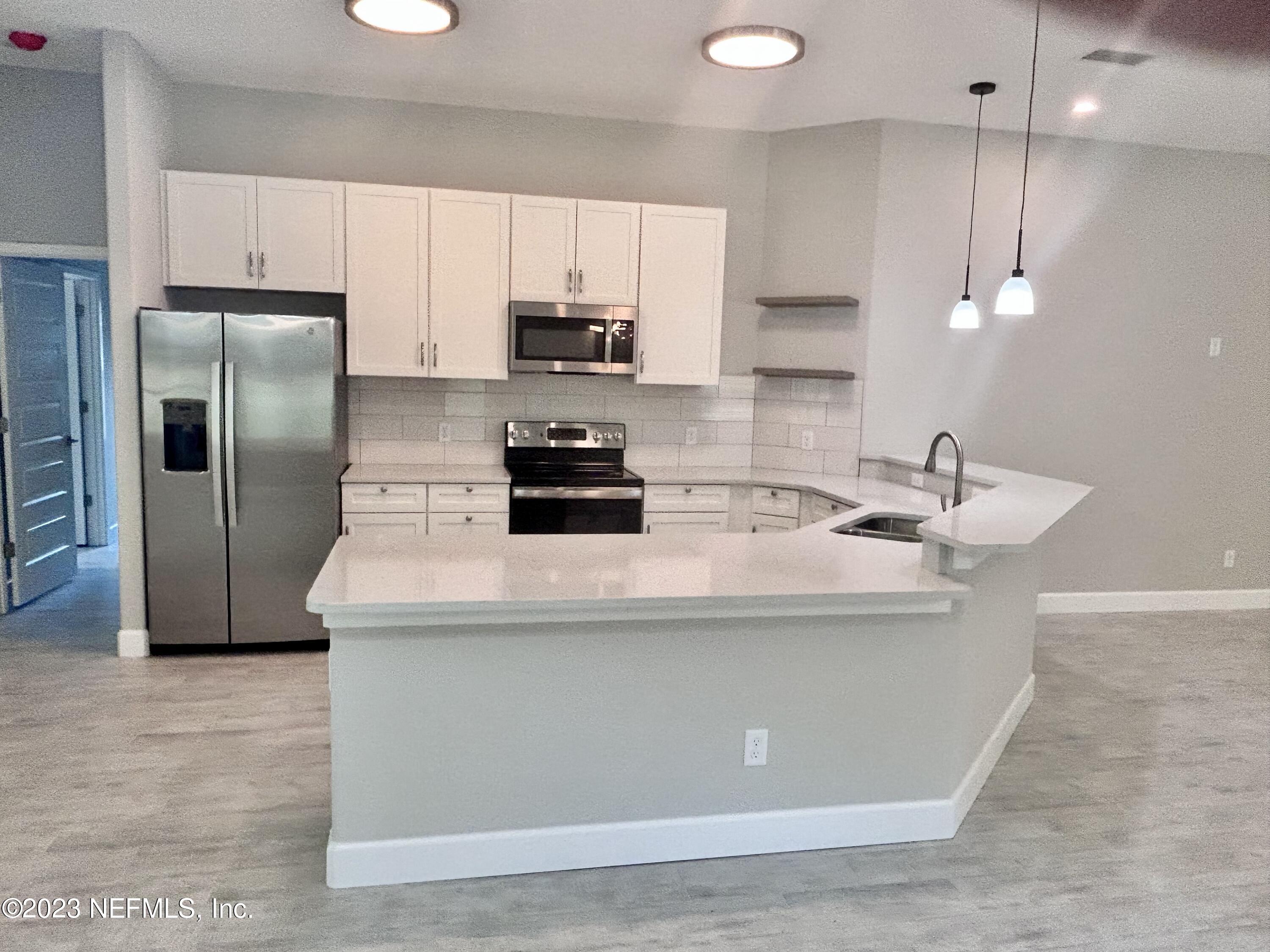 2585 A1A South St. Augustine, FL 32080 - Photo 19 of 37 a kitchen with kitchen island a white cabinets and stainless steel appliances