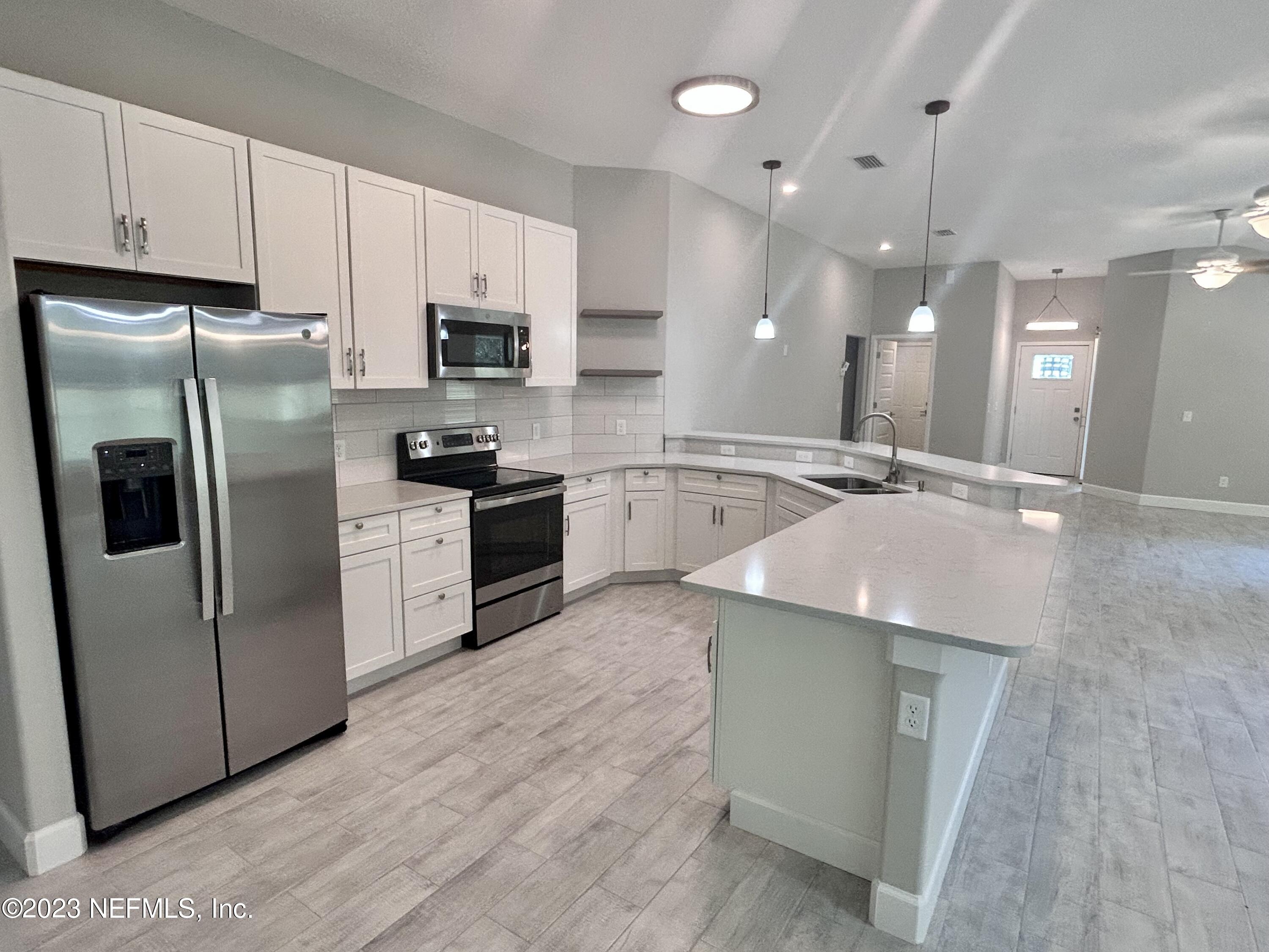 2585 A1A South St. Augustine, FL 32080 - Photo 20 of 37 a kitchen with stainless steel appliances granite countertop a refrigerator a stove a sink and white cabinets
