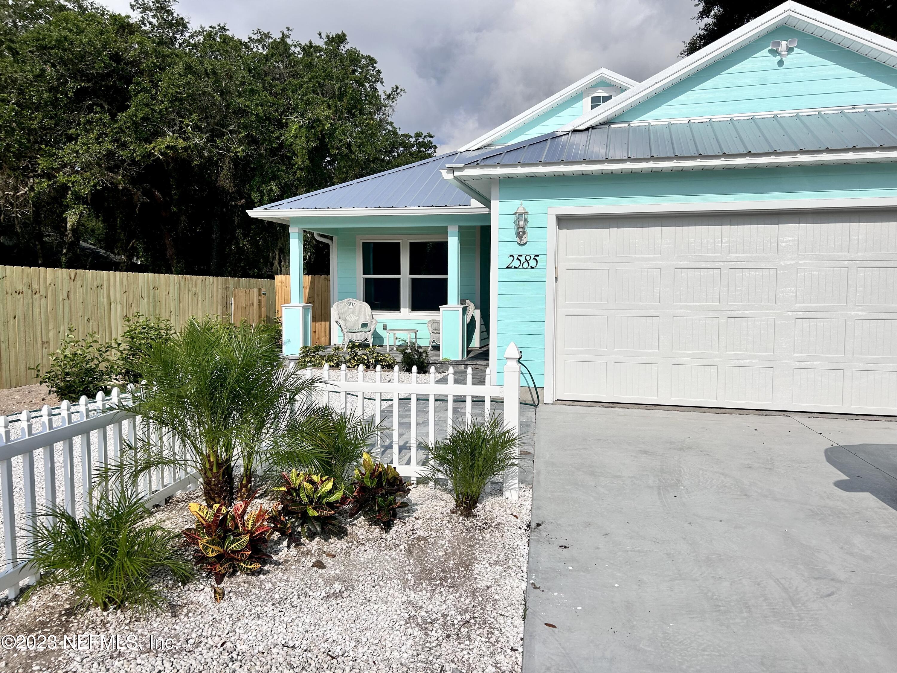 2585 A1A South St. Augustine, FL 32080 - Photo 3 of 37 a front view of a house with a yard and outdoor seating