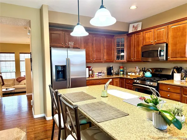 a kitchen with stainless steel appliances granite countertop a sink refrigerator stove and microwave