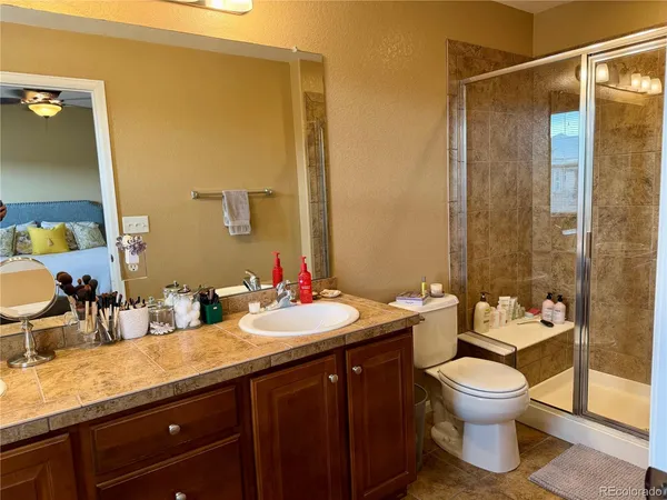 a bathroom with a granite countertop sink toilet and shower