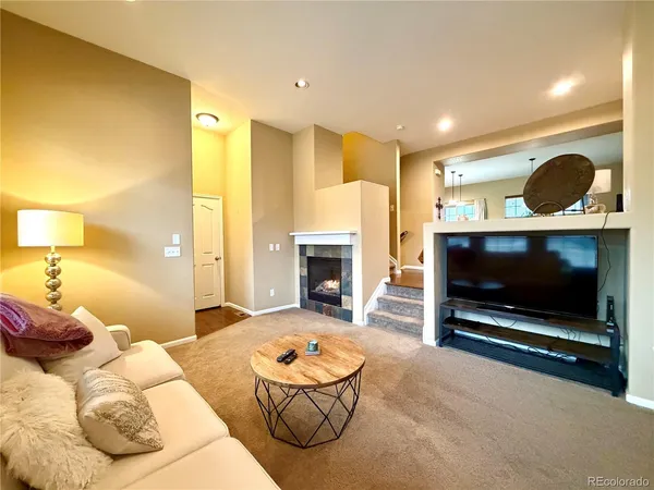 a living room with furniture a fireplace and a potted plant