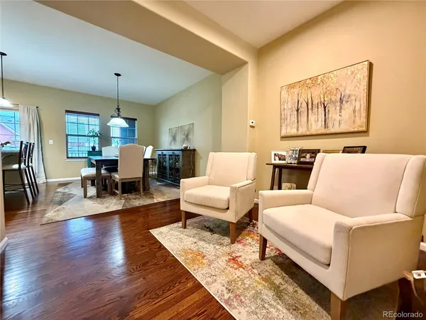 a living room with furniture two lamps and wooden floor