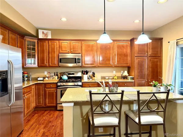 a kitchen with stainless steel appliances a table chairs refrigerator and microwave