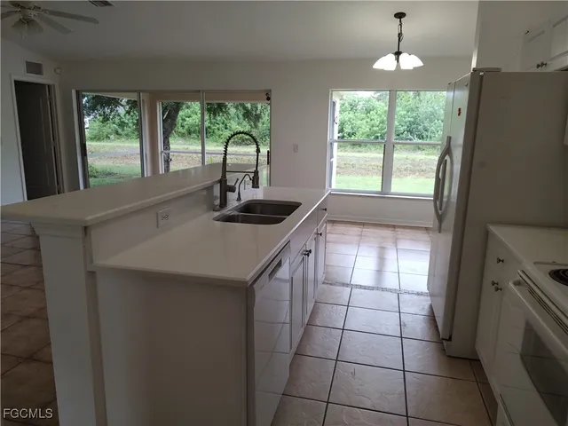 a kitchen with a sink a window and cabinets