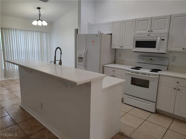 a kitchen with appliances a sink and cabinets