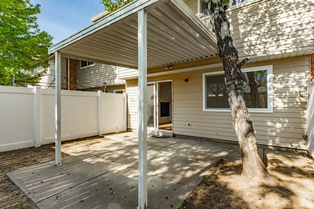 728 400 East Orem, UT 84097 - Photo 13 of 30 Covered concrete patio with white vinyl fencing
