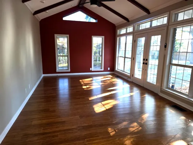 a view of an empty room with glass door and windows