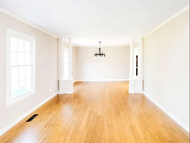 a view of a big room with wooden floor and windows