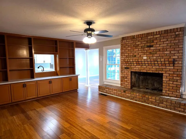 a living room with hard wood floors and a fireplace