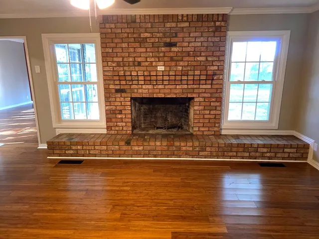 a view of empty room with wooden floor and window