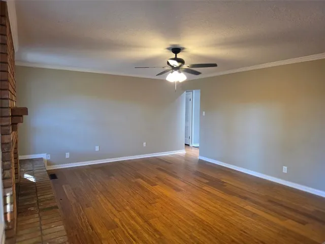 a view of an empty room with a chandelier fan