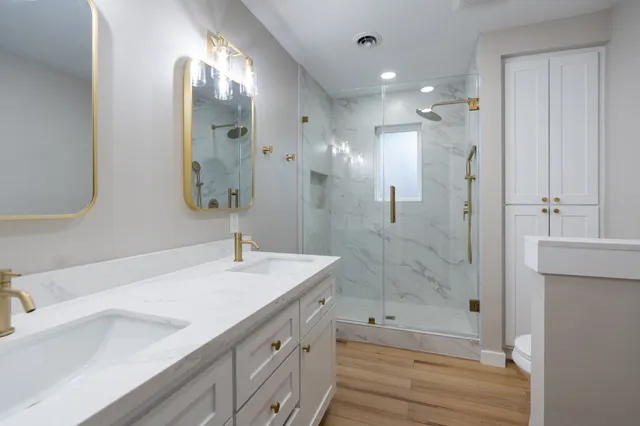 a bathroom with a double vanity sink mirror double and shower