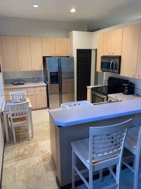 Savanna Weston, FL 33327 - Photo 7 of 9 a kitchen with stainless steel appliances kitchen island granite countertop a table chairs sink refrigerator and microwave