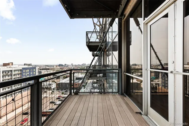 a view of a balcony with wooden floor and iron fence