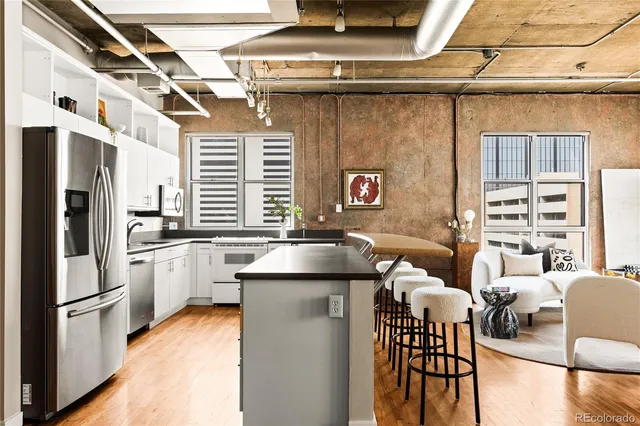 a kitchen with stainless steel appliances a refrigerator and a table