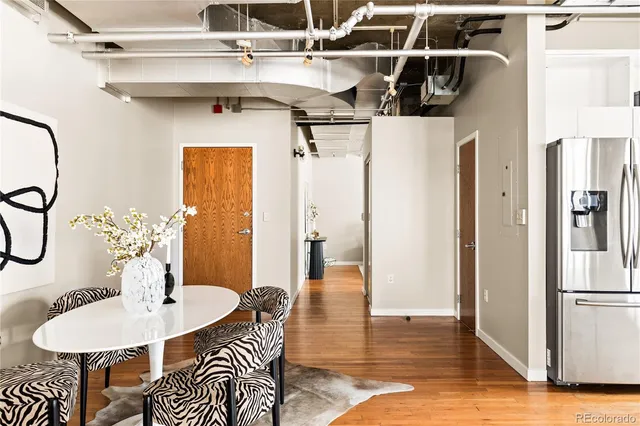 a dining room with wooden floor table and chairs