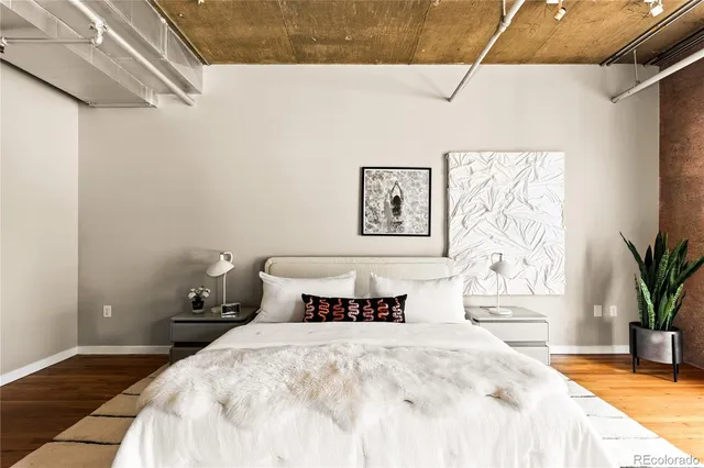 a bedroom with a bed and painting on the wall