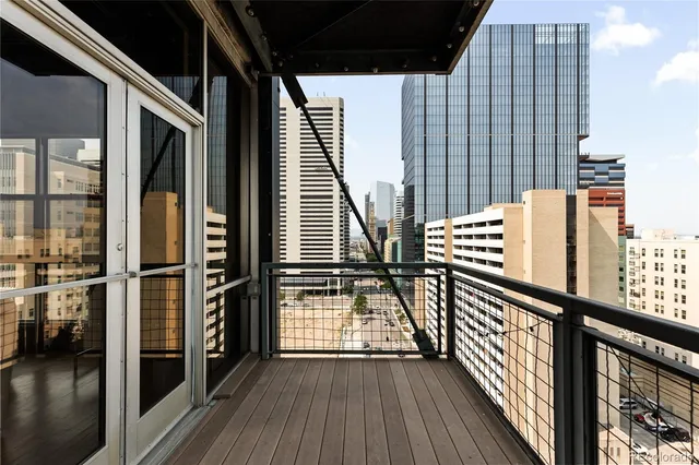 a kitchen with stainless steel appliances granite countertop a refrigerator a sink dishwasher a stove and white countertops with wooden floor