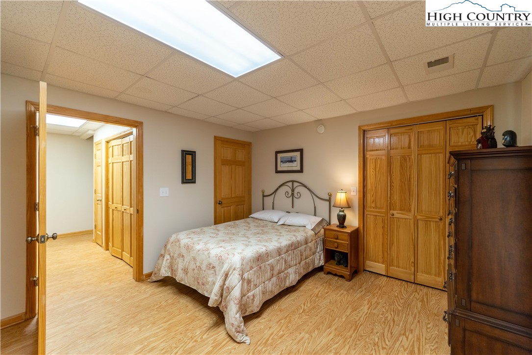 893 Deerwood Road Piney Creek, NC 28663 - Photo 34 of 50 a bedroom with a bed and a refrigerator