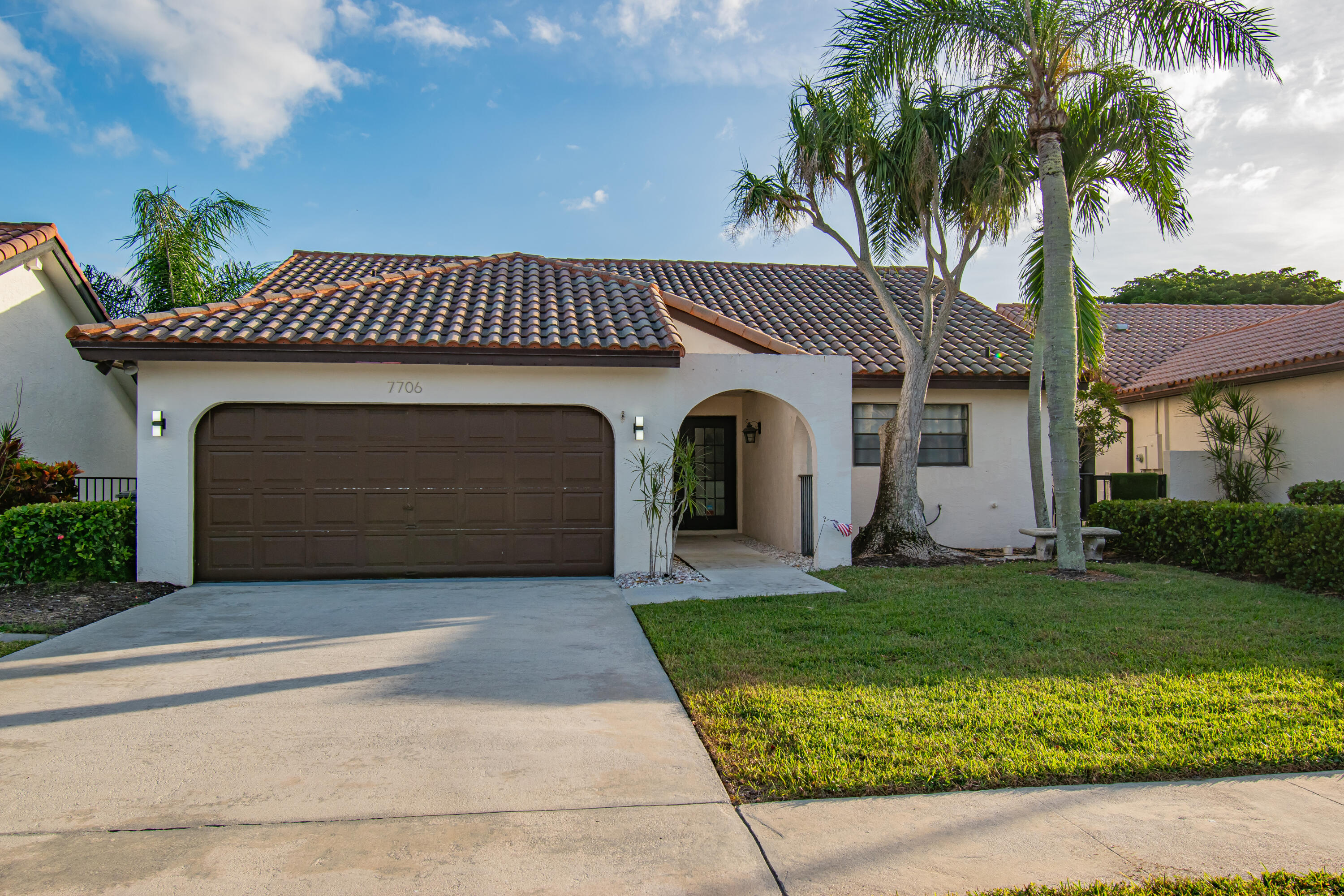 7706 Solimar Circle Boca Raton, FL 33433 - Photo 2 of 28 a front view of a house with a garden