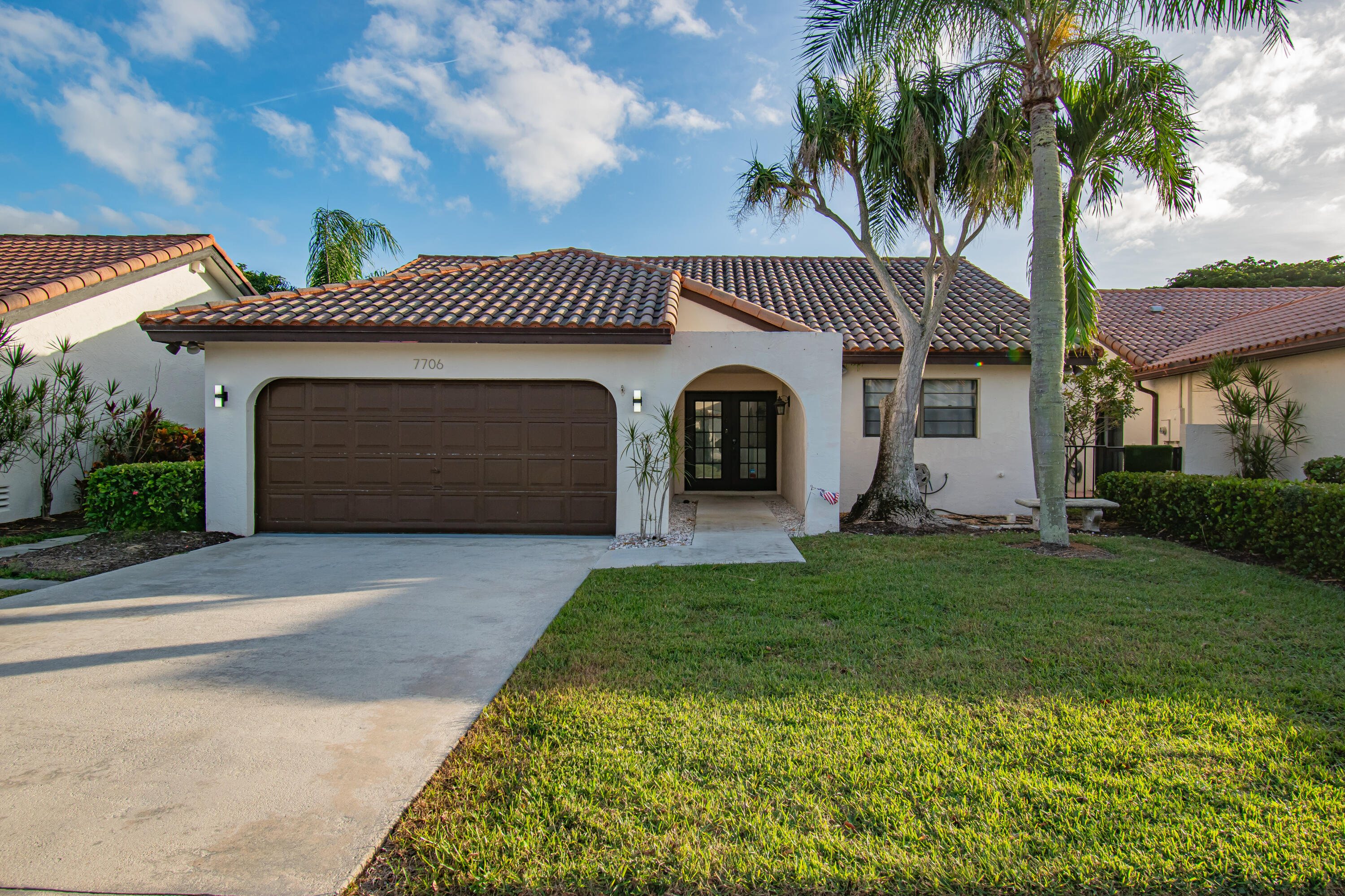 7706 Solimar Circle Boca Raton, FL 33433 - Photo 3 of 28 a front view of a house with a garden