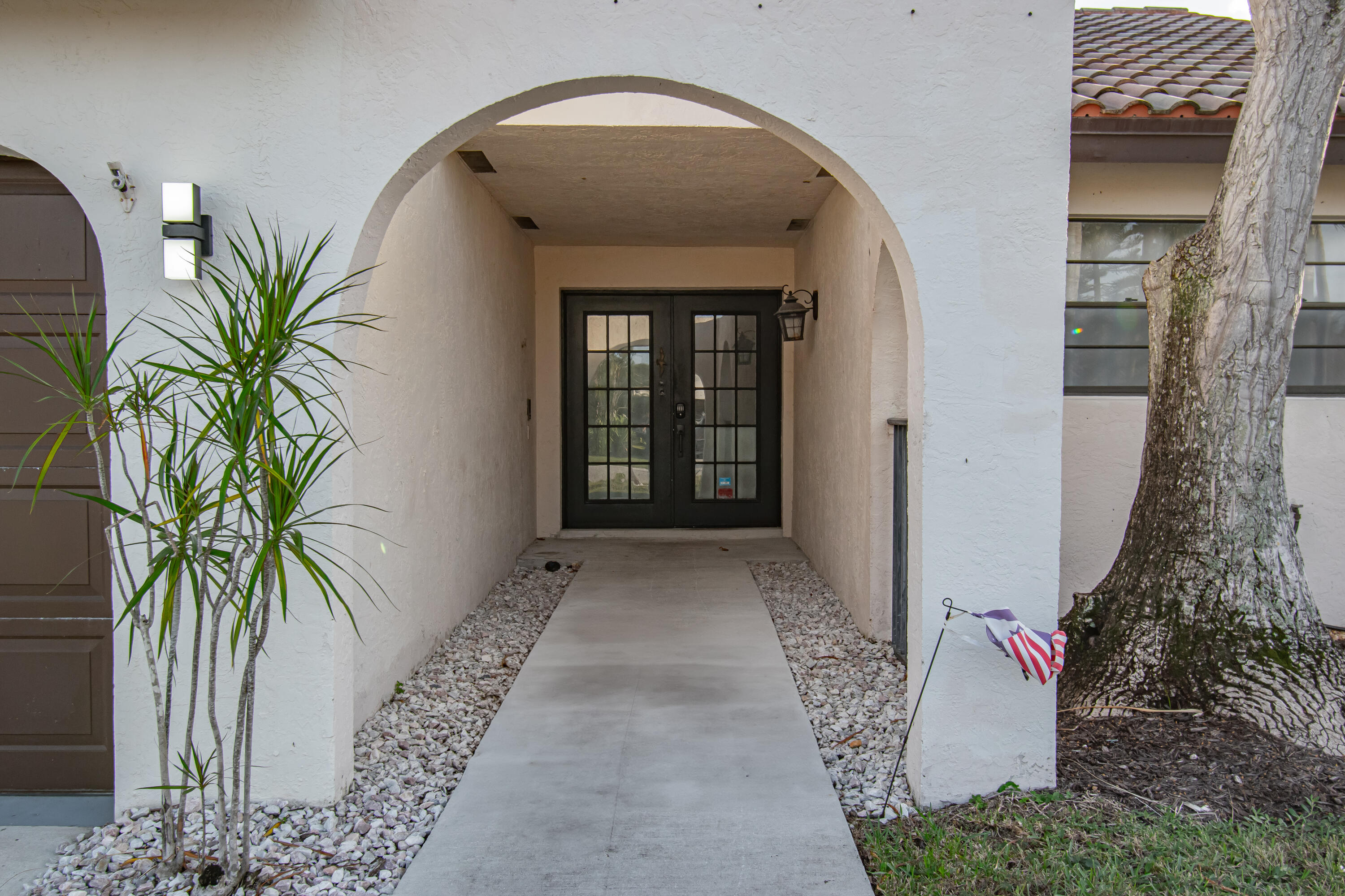 7706 Solimar Circle Boca Raton, FL 33433 - Photo 4 of 28 a view of a entryway door with potted plants