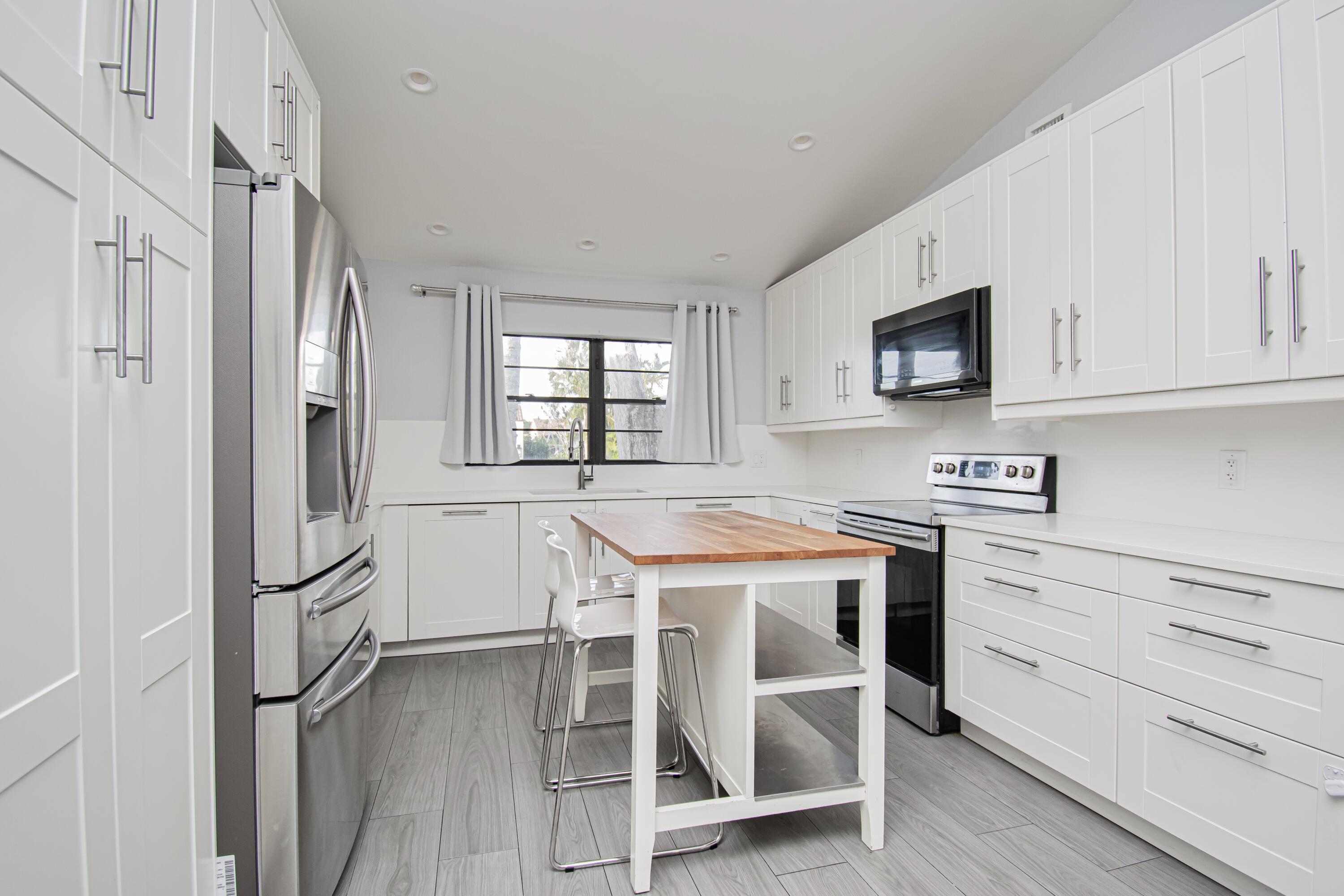 7706 Solimar Circle Boca Raton, FL 33433 - Photo 5 of 28 a kitchen with cabinets and wooden floor