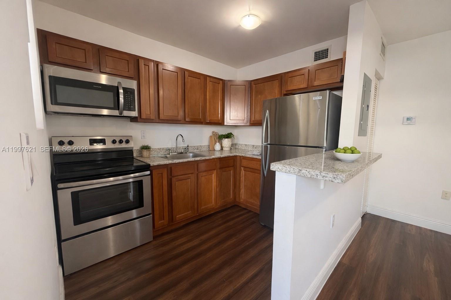 a kitchen with stainless steel appliances a stove a microwave and a hard wood floors
