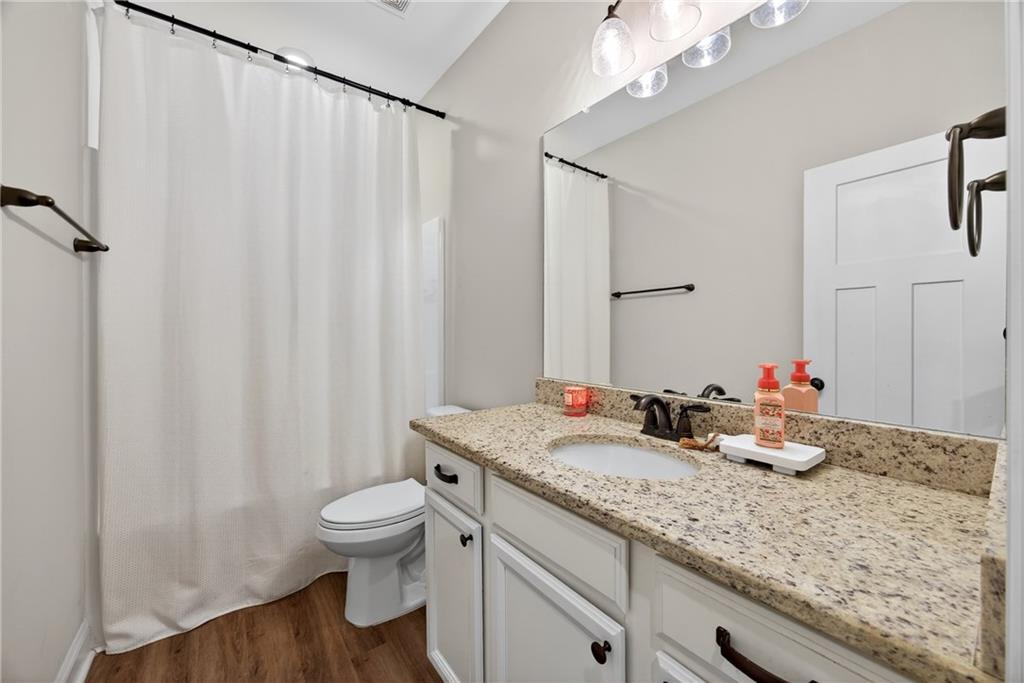 30 Buffelhead Court Monticello, GA 31064 - Photo 14 of 37 a bathroom with a granite countertop sink a toilet and a mirror