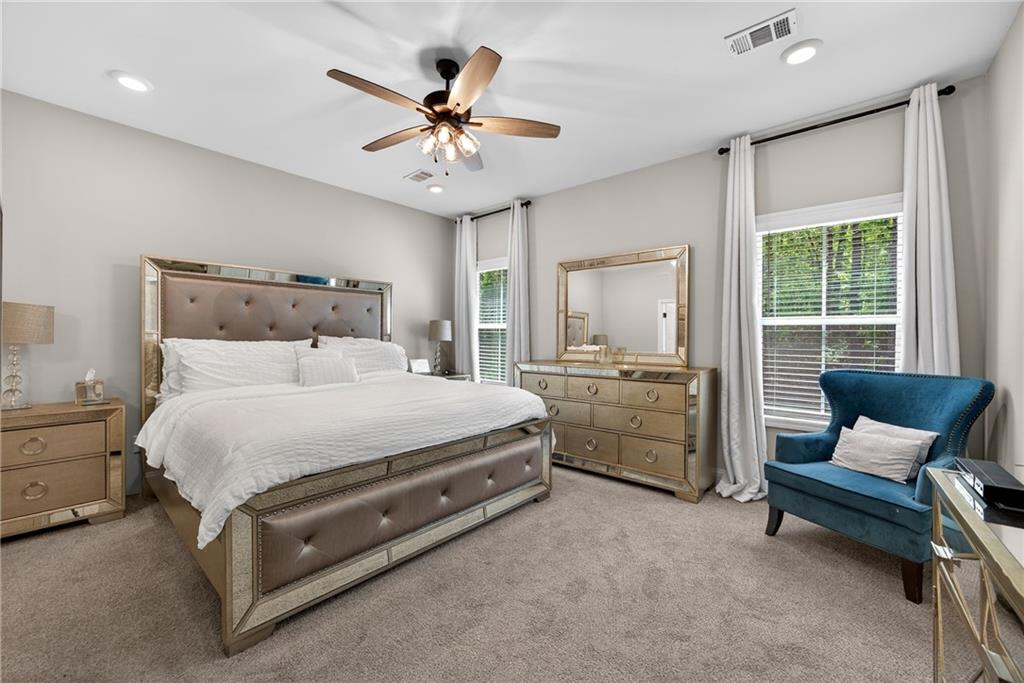 30 Buffelhead Court Monticello, GA 31064 - Photo 16 of 37 a spacious bedroom with a bed a couch and a chandelier