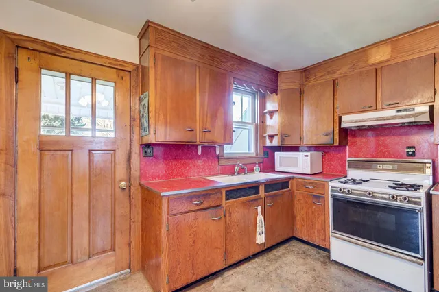 a kitchen with a stove a sink and a microwave