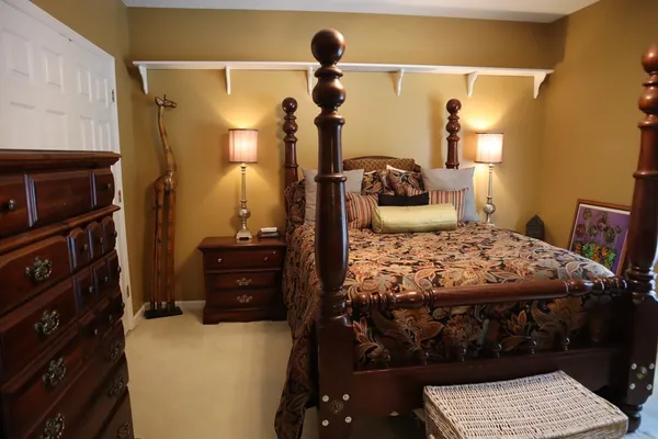 a bed sitting in a bedroom and lamp next to a window