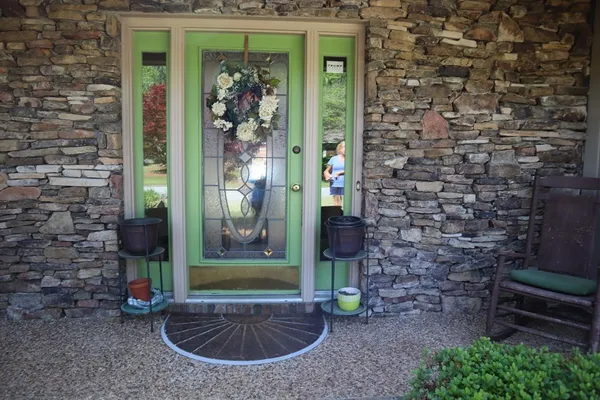 a view of a brick house with a potted plant and a bench