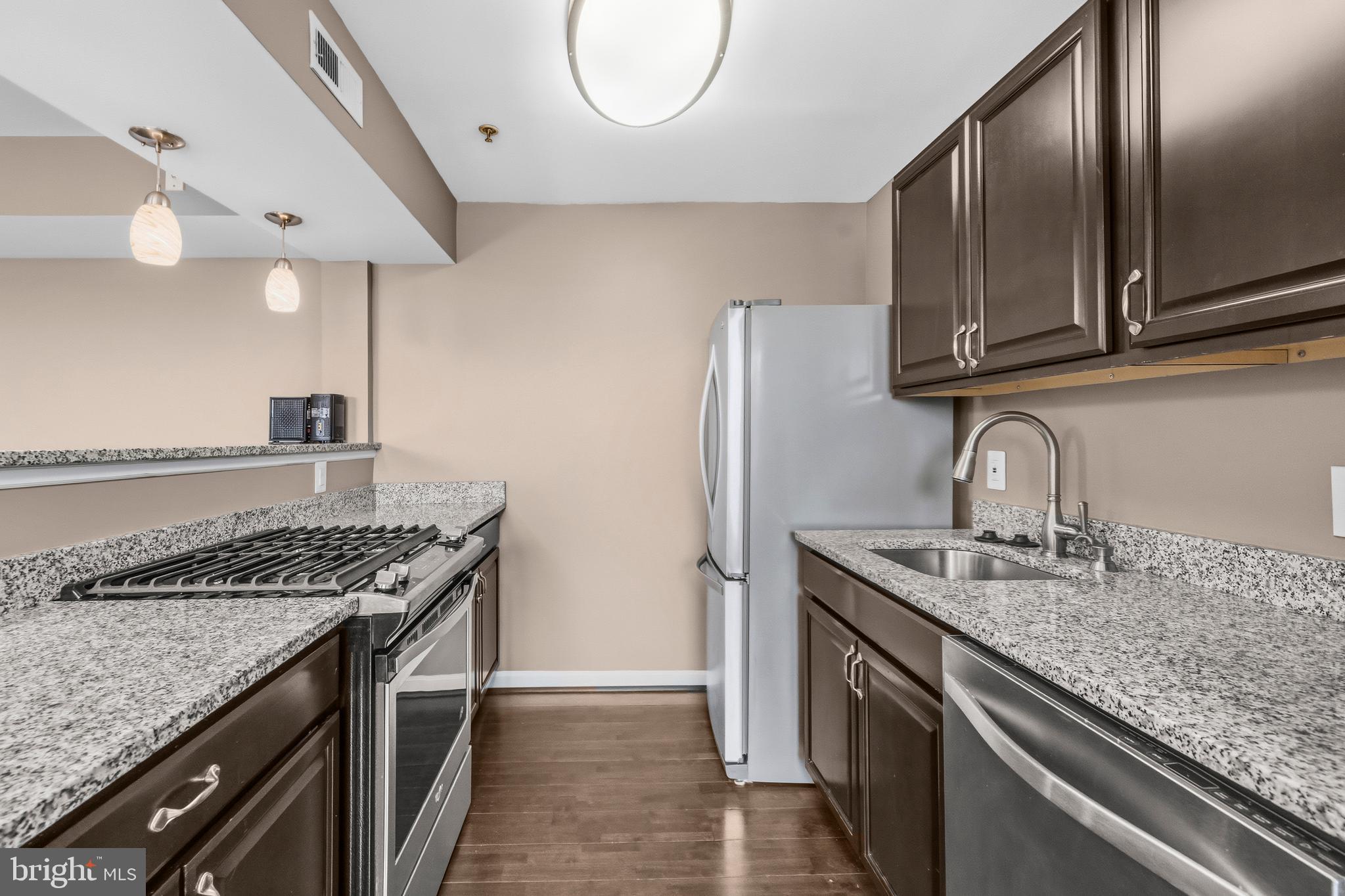 3902 14th Street Northwest, Unit 321 Washington, DC 20011 - Photo 14 of 21 a kitchen with stainless steel appliances granite countertop a sink a stove and a refrigerator