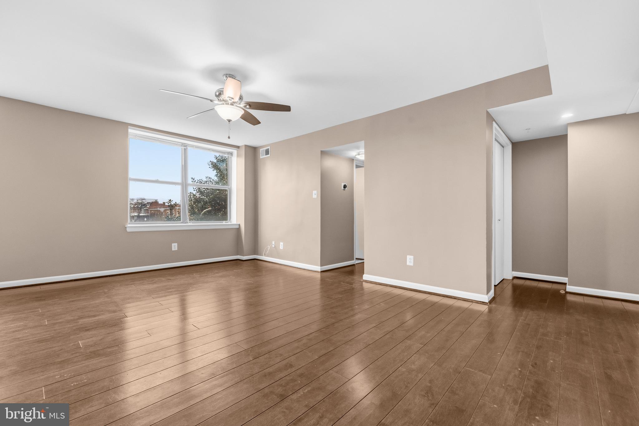 3902 14th Street Northwest, Unit 321 Washington, DC 20011 - Photo 4 of 21 an empty room with wooden floor chandelier fan and windows