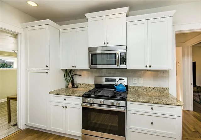 a view of a dining room with furniture a chandelier windows and wooden floor