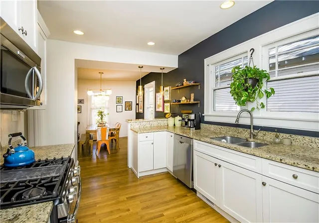 a kitchen with granite countertop white cabinets and stainless steel appliances