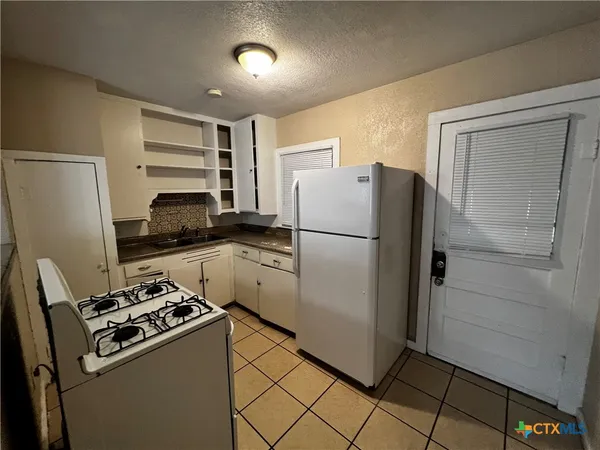 a kitchen with a refrigerator and a stove