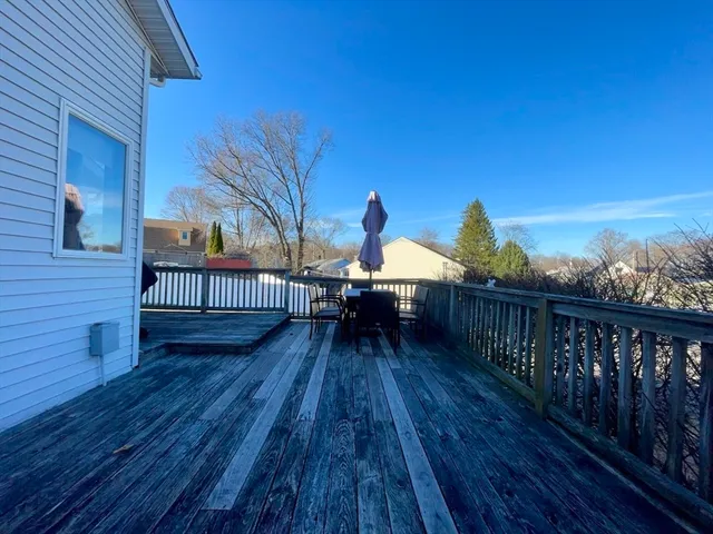 a view of a roof deck with dining table and chair with wooden floor